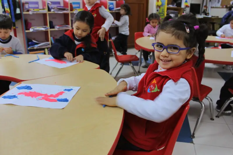 Niña de inicial pintando en el aula