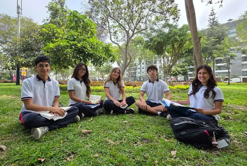 Alumnos de High School leyendo en el jardín