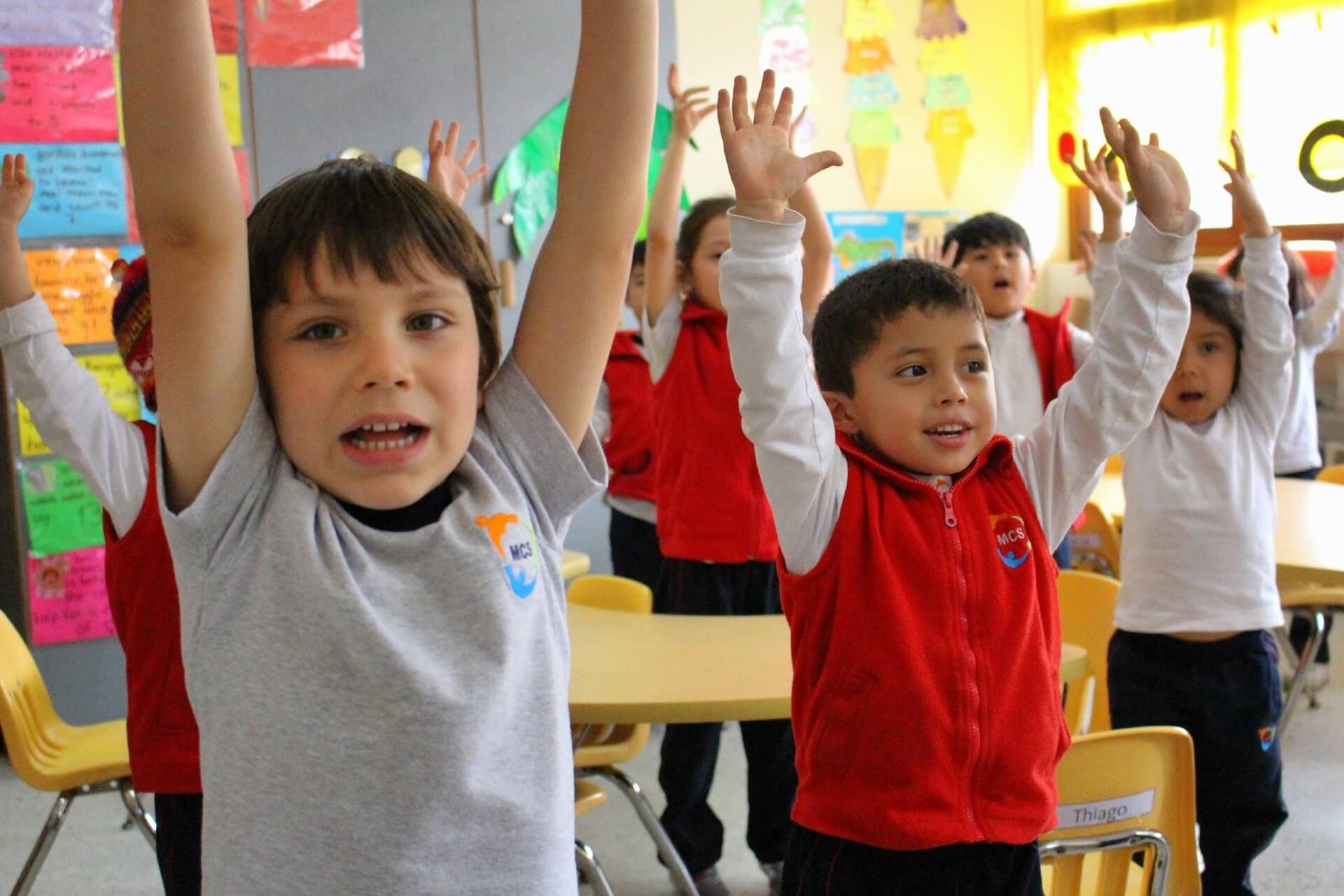 Niños de Monterrico Christian School con las manos en alto en su aula