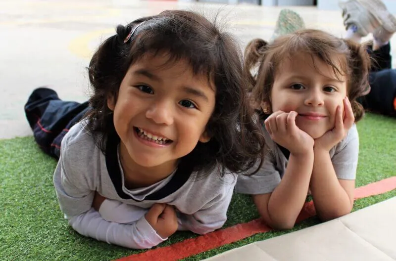 Dos niñas de Early Years sonriendo en el patio