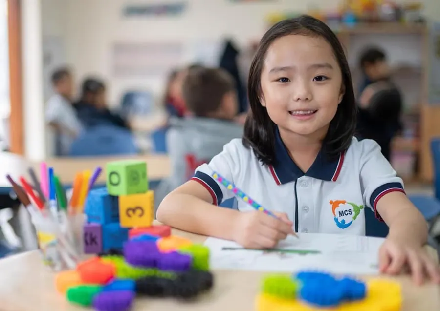Niña dibujando en el aula