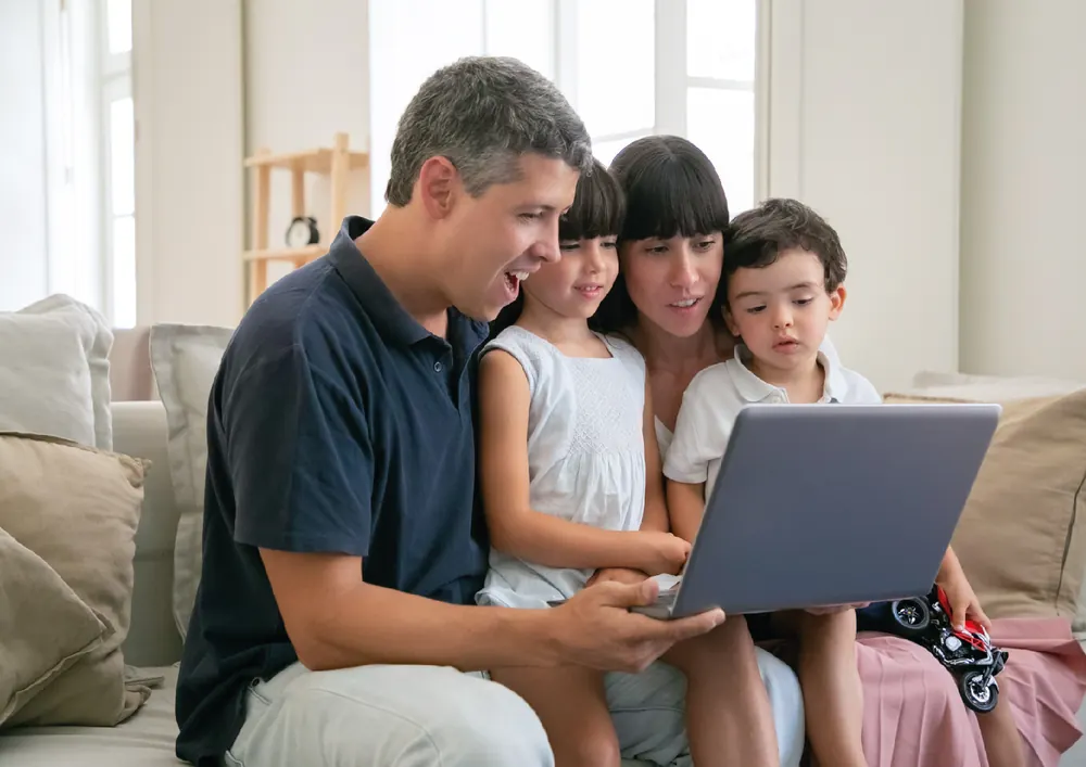 Familia mirando la web del colegio en una laptop